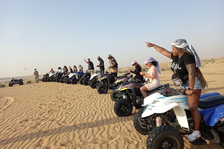 Experience the rush of driving through Dubai's stunning desert dunes on an ATV embracing adventure with camel rides and sand surfing for an unforgettable day in the Arabian sands.